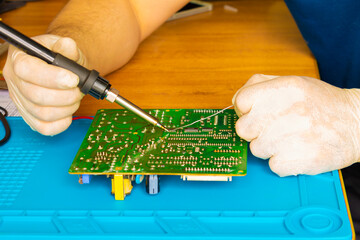 Soldering on the board with a soldering iron and repairing the board with solder