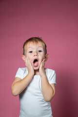Caucasian boy 3 years old makes scary faces while looking at the camera