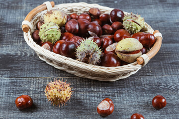 Close up view of Chestnuts in a basket on a wooden background