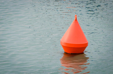 Una boa di segnalazione arancione galleggia nell'acqua di un porto a Venezia