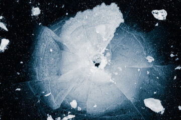 Ice, crushed on black background. Shards of crushed ice spread away. The explosion of ice. Ice with...