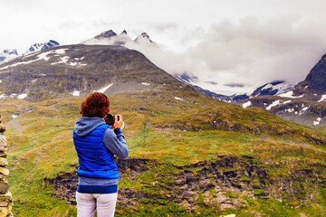 Obraz premium Tourist with camera in Norway mountains