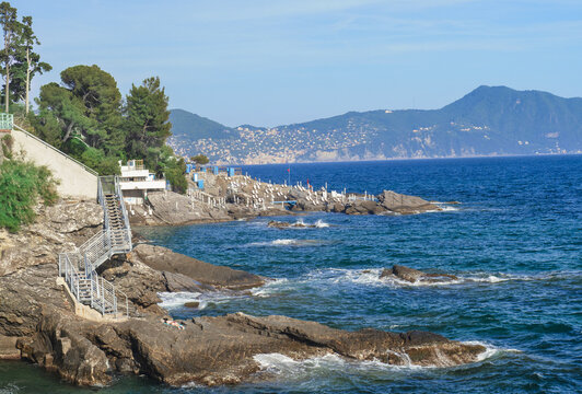 stretch of coast with blue sea. Infrastructure for bathers on the rocks. Paradise Gulf, Genoa, Italy