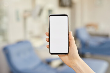 Close up of female hand holding smartphone with blank screen at blood donation center, copy space