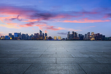 Empty square floor and city skyline with modern commercial buildings in Hangzhou at sunset, China.