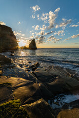 夜明けのろうそく岩と波