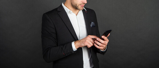 cropped man in suit texting short message on phone, communication