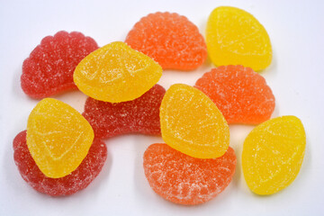 Fototapeta na wymiar Bright, sweet, delicious yellow, orange, red, pink jelly candies located on a white background.