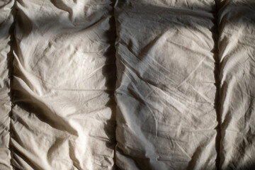 Matting sheet on bed. Texture of fabric in sunlight.