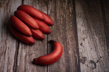 red bananas on wooden background