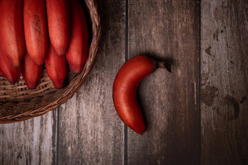 red bananas on wooden background