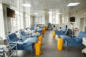 Wide angle view of modern blood donation center interior with chairs and machines, copy space