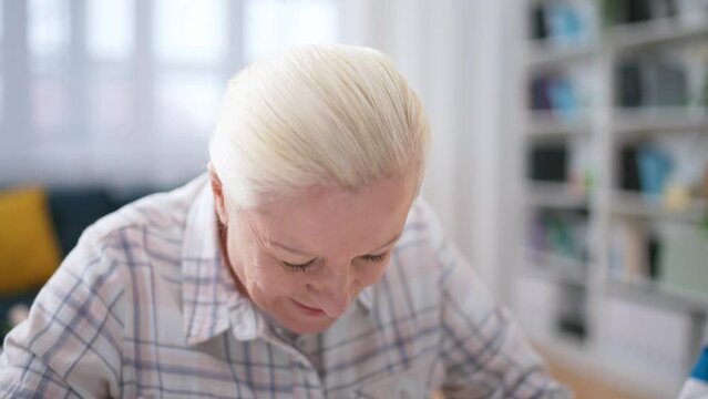 Senior woman connecting jigsaw puzzle pieces, stress relief, brain exercise