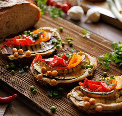 Vegetarian sandwiches with hummus and various vegetables on a wooden board, close-up view. Healthy food - 506249644