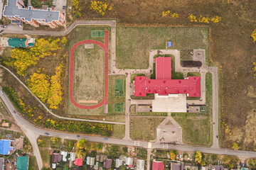 Aerial view of a school or college campus with stadium at village or town