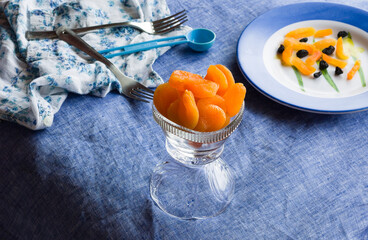 Top view of bowl of sweet,dried turkish apricots, backlit and placed on a dark blue background.