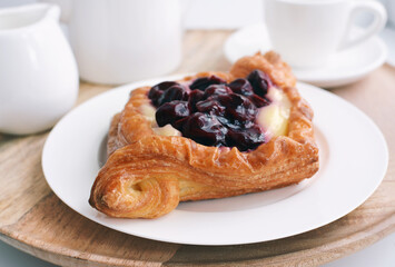 Cherry pie. Sweet cherry and cream, puff pastry dessert on white plate , diamond shaped.