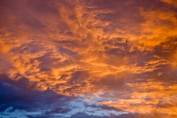 Orange sky merges with blue layered clouds