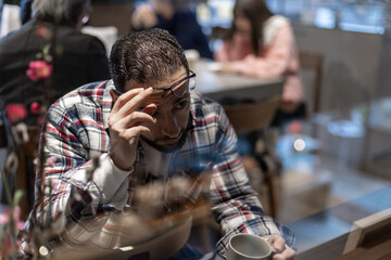 カフェで一人たそがれる中東系男性