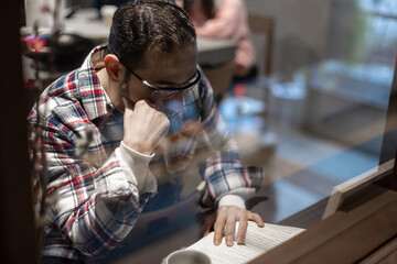 カフェで一人たそがれる中東系男性