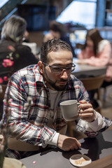 カフェで一人たそがれる中東系男性