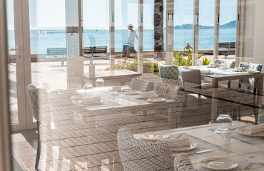 Views of the interior of an empty and closed restaurant, with the tables prepared with cutlery, crockery and glasses. 