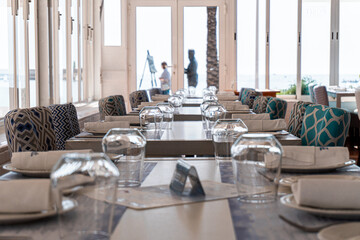 Views of the interior of an empty and closed restaurant, with the tables prepared with cutlery, crockery and glasses. 