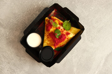 Pancakes with fruits, berries and yogurt on gray background. Healthy food, restaurant dish delivery. Top view. Free space for your text.	