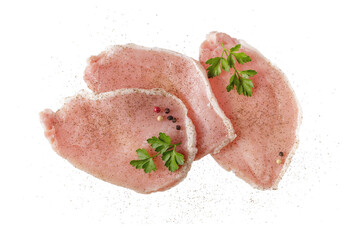 Raw pork meat steaks with parsley and pepper isolated on white. Pork filet pieces for baking,...