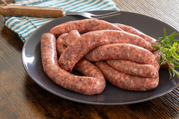 raw sausages for grilling in a plate on a table