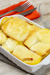 potato with raclette cheese on wooden table