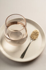 Protein powder and a spoon with glass of water. Food supplements