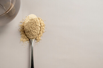 Heap of protein powder and a spoon with glass of water. Food supplements