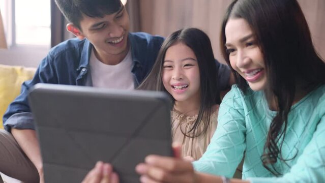 happiness asian family daughter stay together at home using tablet taking selfie photo or video calling to grandparent distancing communication,portrait of selfie family together in living room home