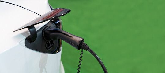 Close up of electric car with a connected charging cable