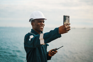 Black maritime worker making video call in sea