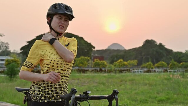 Asian female cyclist having neck pain from riding a bike long time. Poor posture is a major contributor to neck pain whilst cycling.