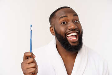 portrait of a happy young dark-anm brushing his teeth with black toothpaste on a white background.