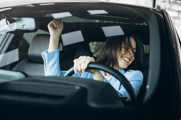Woman driving car and dancing