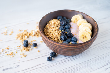 granola with banana and blueberries with pink sweet yogurt