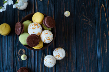 multicolored macaroon cakes on a dark wooden background