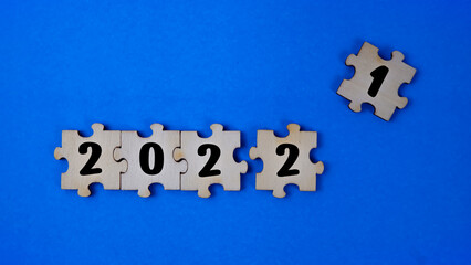 Jigsaw puzzle with the year number isolated with blue background. 2022 will come and 2021 will go.
