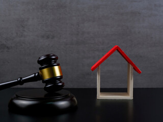 Wooden law gavel and wooden house. Auction concept.