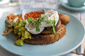 Healthy breakfast from poached eggs, grilled halloumi, Scrambled smoked harissa tofu, smashed avocado, grilled mushrooms and tomato beans on toast