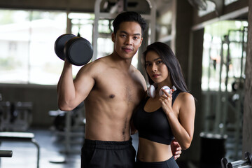 Fototapeta na wymiar Fit sporty Asian couple portrait at fitness gym