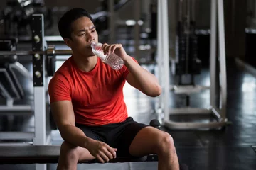 Crédence de cuisine en verre imprimé Fitness Young Asian strong muscular man drink water in fitness gym