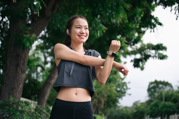 Happy beautiful girl stretching arm before jogging 