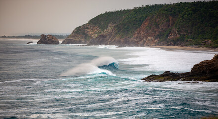 perfect wave crashing on rocks