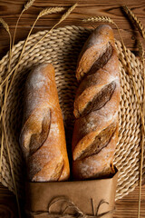 French baguette, long loaf with
wheat ears on the wooden table