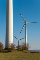 Close-up of a wind turbine tower with two other turbines in the background, suitable as a symbolic image for renewable energies, near Höxter, Weserbergland, Germany